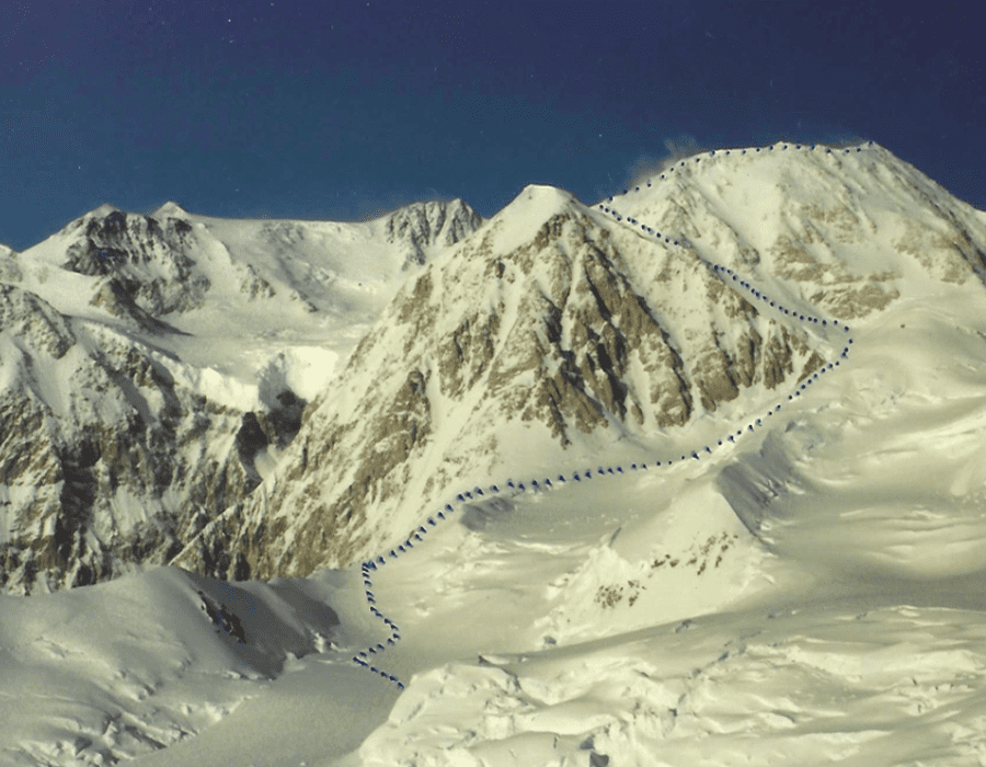 Snow-covered mountain range under a clear blue sky.