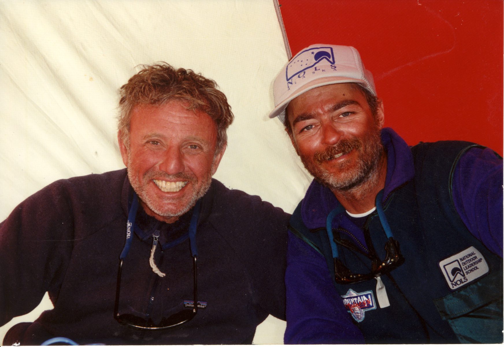 Two smiling men posing together in casual outdoor attire.