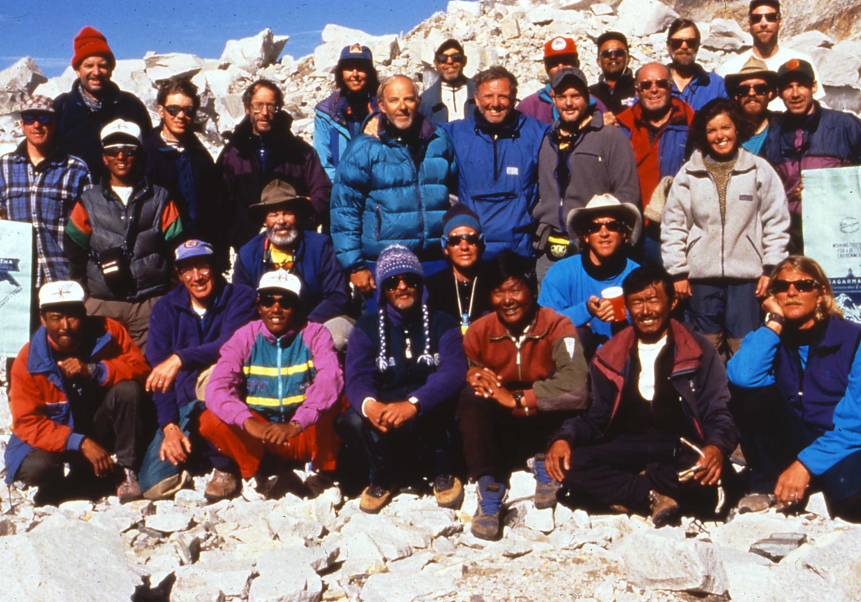 Group photo of hikers on a snowy mountain summit.