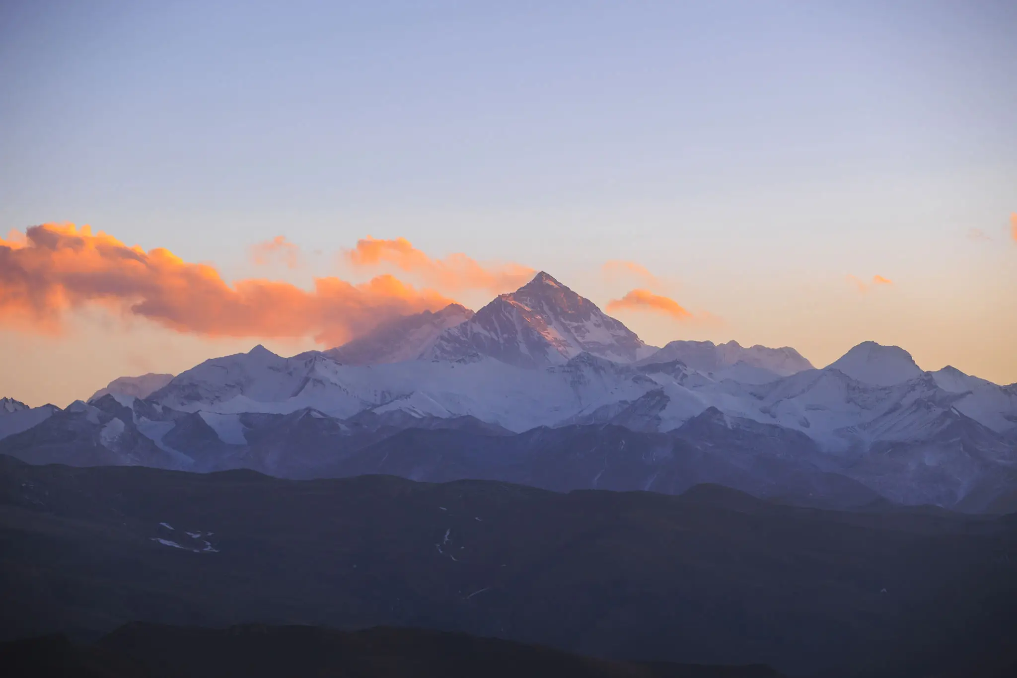 Mountain peak at sunset with orange clouds