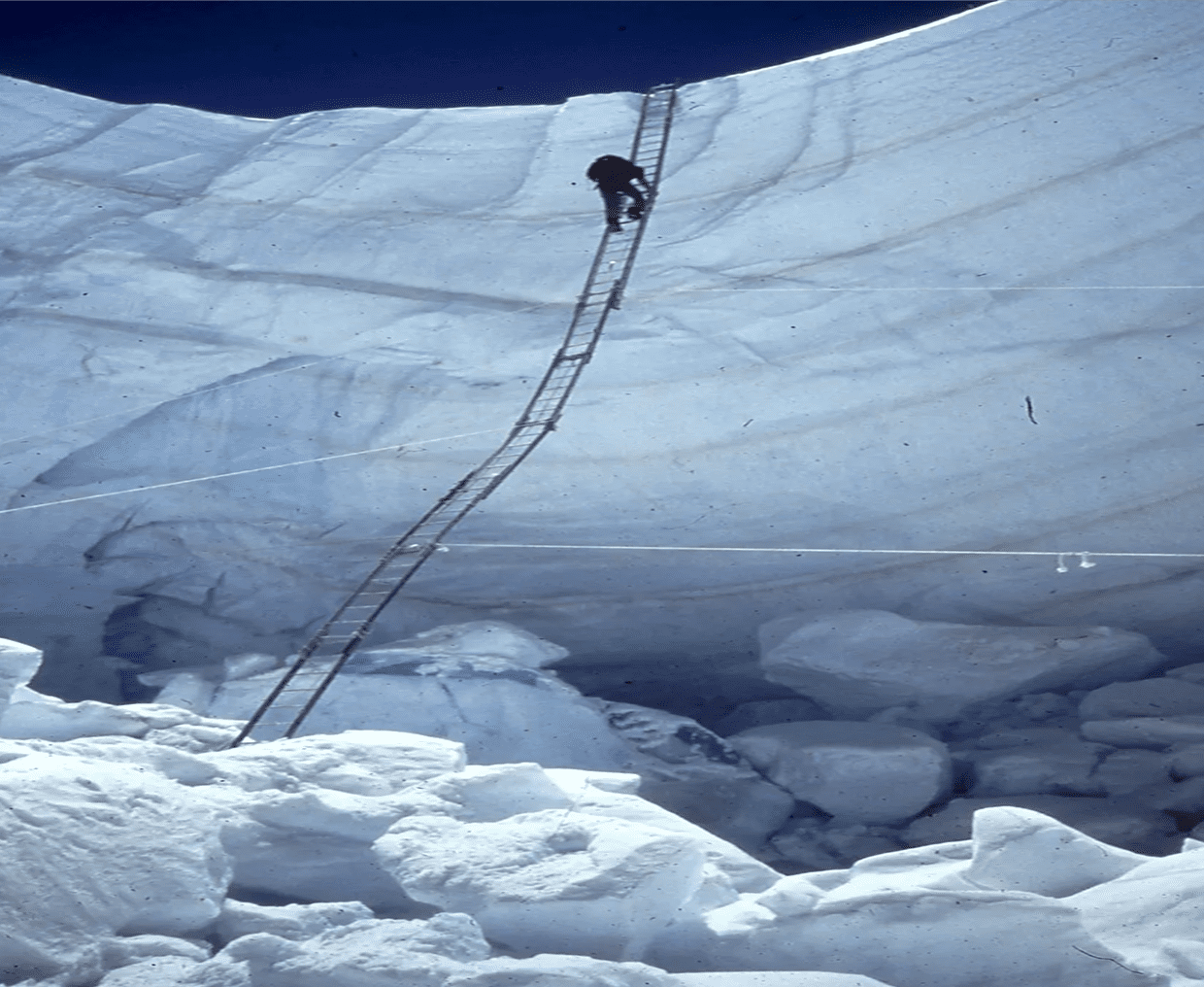 Ice climber navigating a precarious ladder