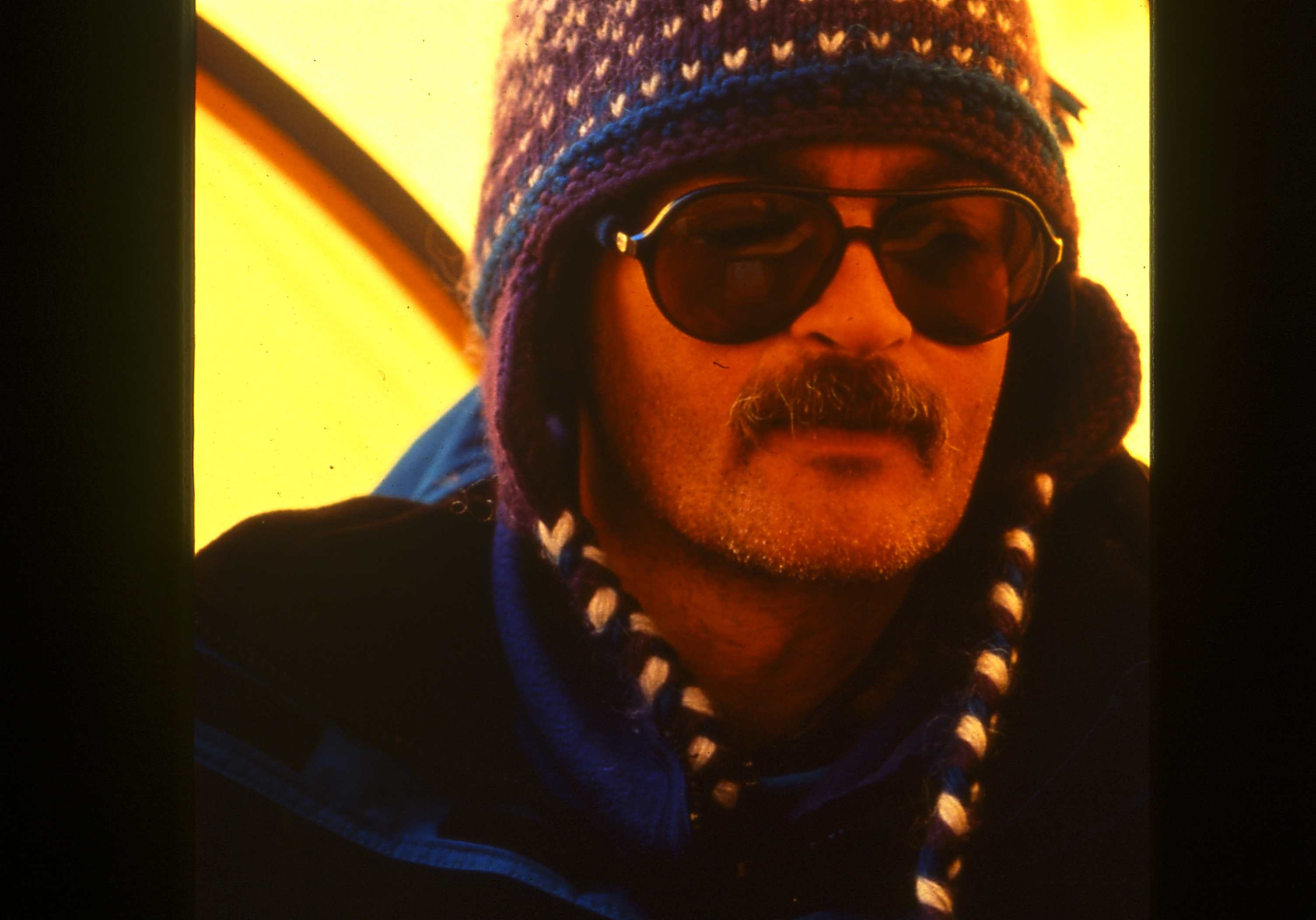 Man wearing sunglasses and a patterned knit hat.
