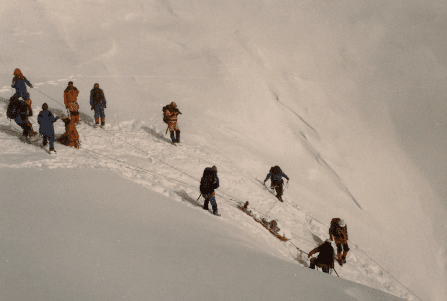 Group of climbers ascending a snowy mountain slope.