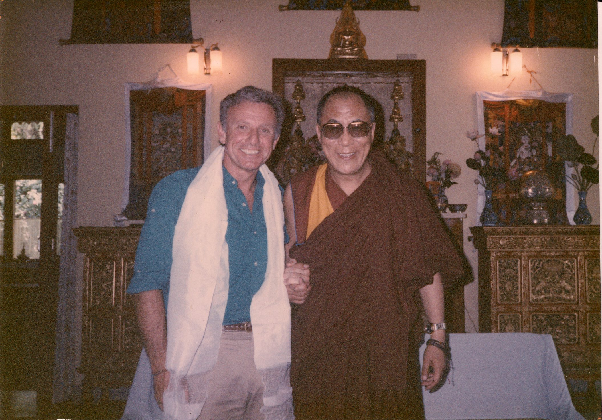 Two men posing together indoors, one in traditional attire.