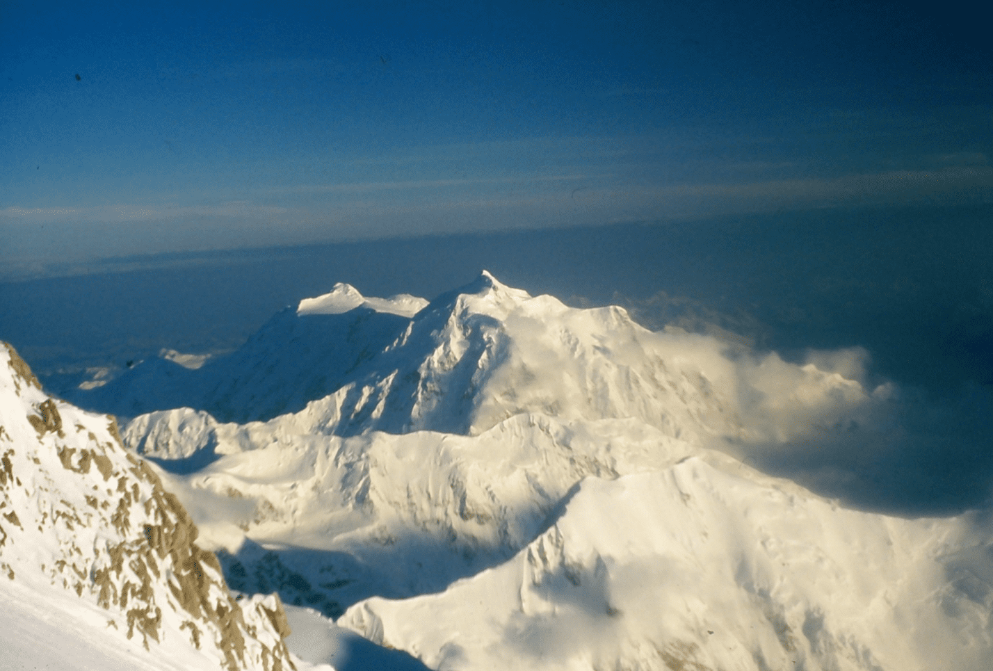 Snow-covered mountain peaks under a clear blue sky.
