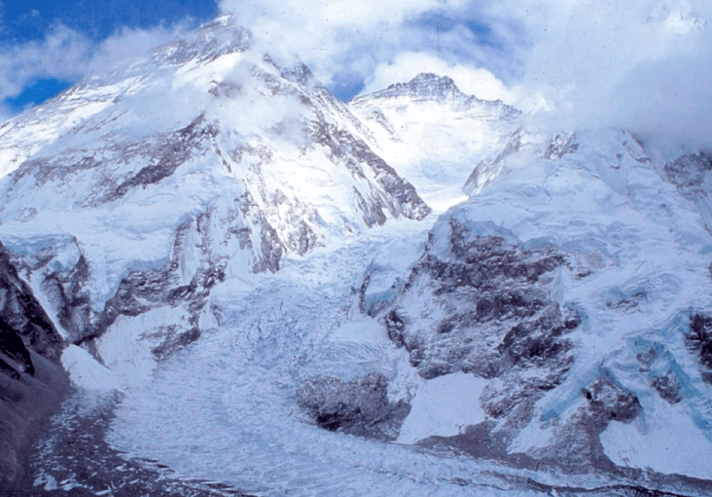 Snow-covered rugged mountain peaks under a cloudy sky.